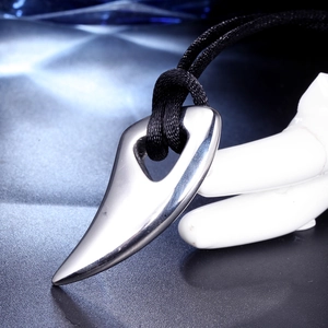 Close-up of polished stainless steel horn pendant with a black woven cord necklace