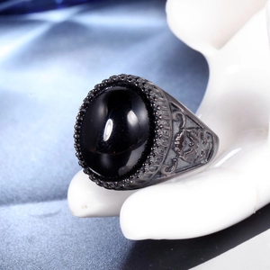 Dettaglio macro di anello vintage da uomo con agata nera e stemma in rilievo