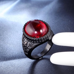 Dettaglio macro di anello gotico da uomo con grande pietra rossa e rilievo nero vintage