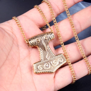 Goldener Mjölnir Thorshammer Anhänger Halskette mit nordischen Gravuren in der Hand