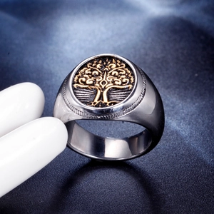 Macro view of vintage stainless steel signet ring with golden tree of life engraving