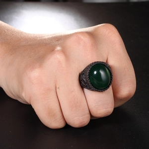 Dettaglio macro di anello vintage da uomo in lega nera con grande agata verde ovale