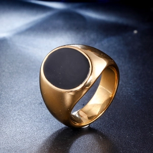 Macro detail of men's gold stainless steel signet ring with a round black onyx inlay
