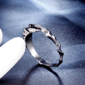 Macro shot of minimalist vintage silver ring with irregular wave texture on blue silk