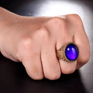 Dettaglio di un anello a sigillo vintage dorato con una grande pietra viola intarsiata
