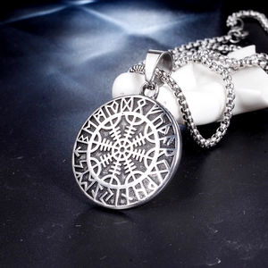Vintage Viking compass necklace with runes on black rock background, Norse jewelry style