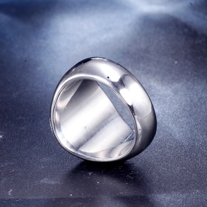Macro close-up of polished stainless steel wide band ring with a glossy silver finish