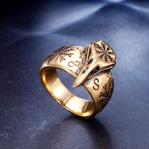 Macro detail of retro eagle skull ring featuring Nordic runes and a polished gold finish