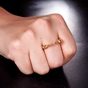 Close-up of golden punk style double beast head ring on hand with engraved metal textures