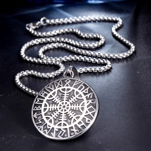Close-up of a vintage silver Viking compass pendant necklace with Nordic rune engravings