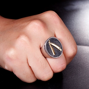 Macro shot of vintage titanium steel signet ring with golden barber razor emblem