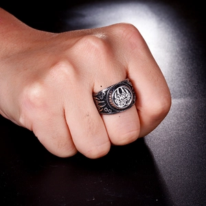 Detailed close-up of a vintage steel bear paw ring with Celtic knots on a male hand