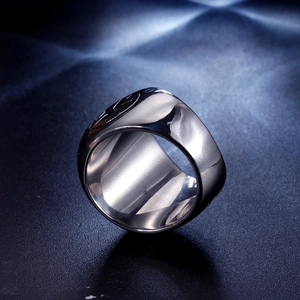 Macro shot of polished stainless steel ring featuring a heart-engraved gothic cross pattern