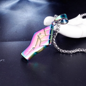 Detail of punk iridescent stainless steel fist pendant with abstract geometric carvings