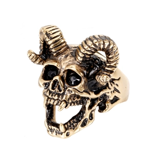 Macro detail of gothic ram skull ring with black gemstone eyes and golden finish