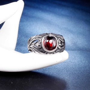 Vintage stainless steel ring featuring a large oval red gemstone with ornate carvings