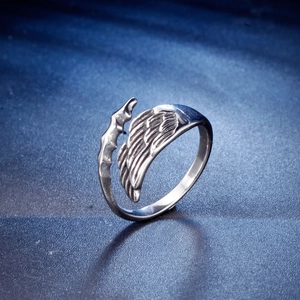 Vintage stainless steel open ring with angel wing and gothic bone texture on blue background