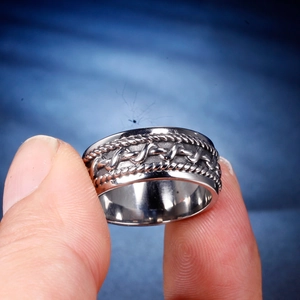 Gros plan d'une bague large pour homme en acier inoxydable aux motifs torsadés vintage