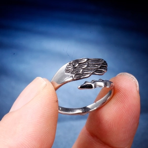 Close-up of vintage stainless steel angel wing ring with detailed feather texture