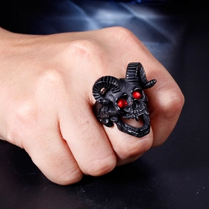 Close-up of punk ram skull ring with matte black finish and red rhinestone eyes