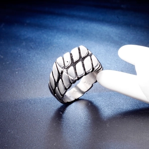 Detail of vintage brushed stainless steel ring featuring geometric tire tread pattern