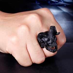 Close-up of a punk-style black stainless steel ram skull ring worn on a hand