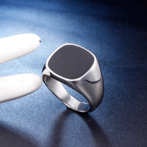 Men's silver signet ring with a minimalist square black enamel inlay on a textured surface