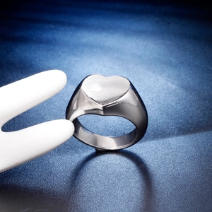 Bague chevalière cœur en acier inoxydable argenté sur fond bleu marine texturé