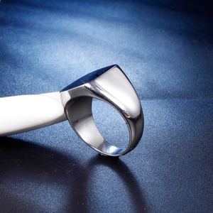 Polished silver square signet ring displayed on a modern white stand with a blue background