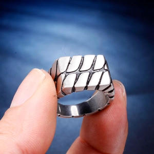 Detailed macro shot of men's stainless steel ring with industrial geometric texture