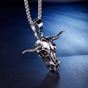 Pendentif tête de taureau vintage en acier inoxydable avec chaîne sur fond sombre