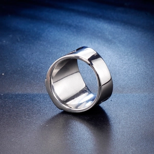 Close-up of polished stainless steel wide band ring with mirror finish on blue background