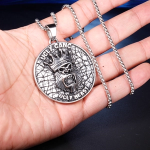 Macro shot of silver punk gorilla pendant with Ugly Gang engraving on a box chain
