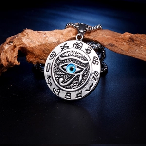 Collier avec pendentif œil de Horus en argent antique et perle bleue sur bois sombre