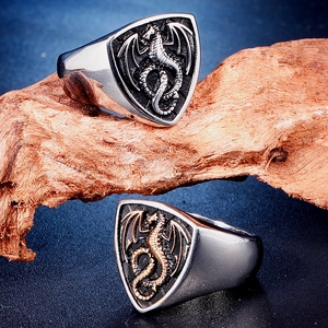 Macro detail of vintage dragon emblem rings in silver and gold-tone stainless steel