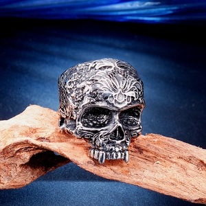 Macro d'une bague tête de mort en acier avec gravures gothiques florales sur bois