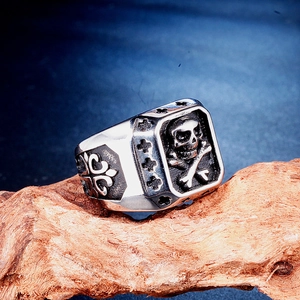 Retro punk skull and crossbones ring in silver finish on natural driftwood
