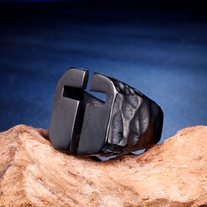 Gros plan de la bague large noire style spartiate avec texture martelée sur bois