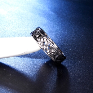 Macro detail of vintage hollow vine patterns on men's titanium steel gothic ring