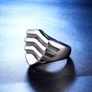 Macro shot of men's geometric shield ring with linear grooves and cool blue metallic glow