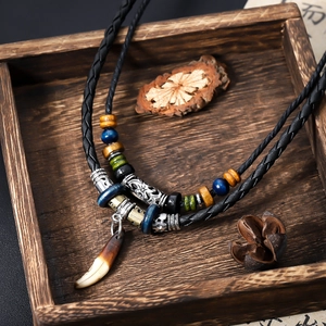 Collier ethnique dent de loup avec perles colorées et cordon en cuir noir