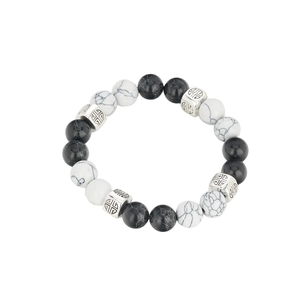 White turquoise and black beaded bracelet with engraved silver charms on a white background