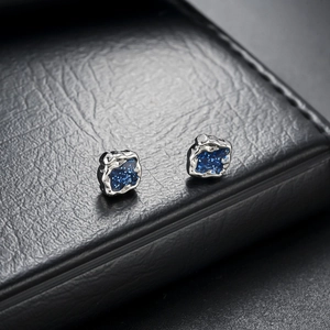 Silver lava textured magnetic stud earrings featuring a sparkling dark blue galaxy inlay