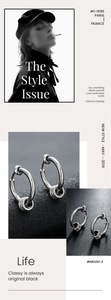 Close-up of minimalist silver hoop earrings with triple rings on black leather texture