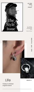 Détail de boucles d'oreilles créoles avec pendentif zircon carré sur roche noire
