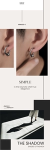 Close-up of minimalist silver hoop earrings with three small rings in artistic shadow
