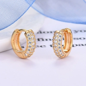 Macro detail of gold hoop earrings with three rows of sparkling pave-set white zircon stones
