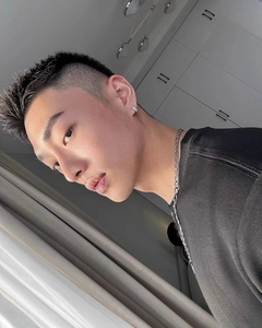 Close-up of men's sparkling hoop earring with silver chain necklace on male model