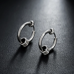 Polished silver metal hoop earrings with triple band wrap detail on dark texture