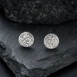 Vintage silver dragon pattern clip-on earrings displayed on a dark natural rock surface
